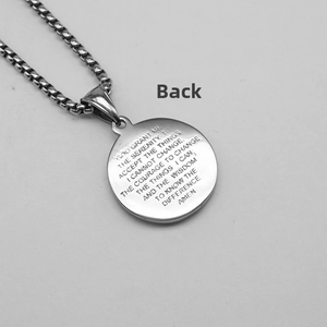 Macro view of the engraved Serenity Prayer on a silver stainless steel circular pendant
