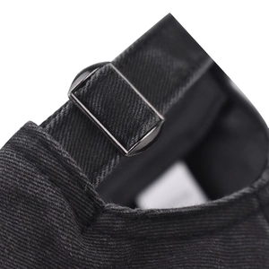 Close-up of black washed cotton baseball cap with adjustable strap and metal buckle