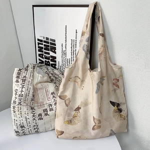 Detail of canvas tote bags with butterfly and Chinese calligraphy prints in a studio setting