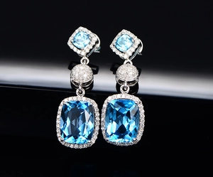 Detailed macro view of cushion-cut blue gemstone earrings with diamond pavé settings