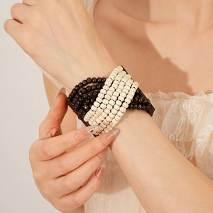 Detail shot of multi-layer wooden beaded bracelet worn on wrist with bohemian style
