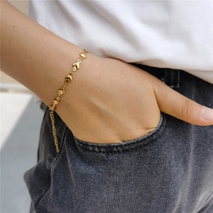 Élégant bracelet chaîne à maillons cœur dorés avec fermoir mousqueton sur un poignet