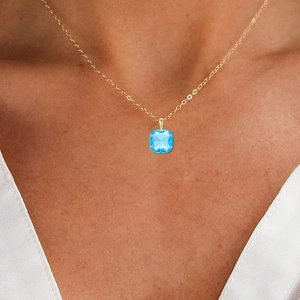 Detail of s925 silver gold chain with a square-cut blue crystal gemstone pendant