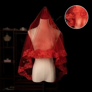 Detail of red bridal veil with intricate lace embroidery edge on transparent tulle