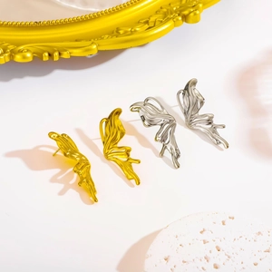 Y2K style butterfly wing stud earrings in gold and silver liquid metal finish