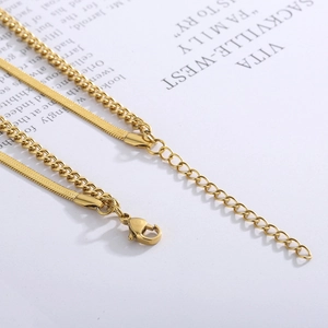Detailed view of layered 18k gold snakeskin and cuban chains with secure lobster clasp
