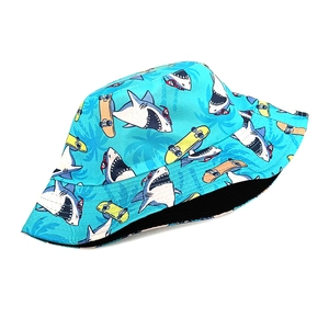 Detailed view of blue bucket hat with shark and skateboard patterns and neat stitching