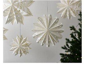 Detailed close-up of cream paper star ornaments with intricate cut-outs for Xmas decor