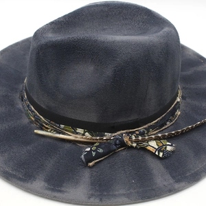 Detail of charcoal wool felt hat featuring ethnic floral band and decorative feather