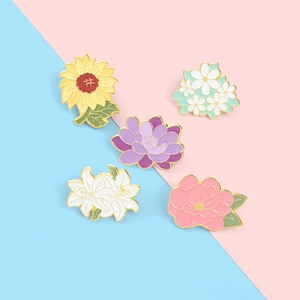 Five-piece set of colorful sunflower and lily enamel pins with gold trim on bicolor background
