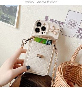 Detail view of quilted leather phone case with butterfly pattern and crossbody chain