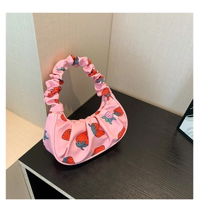 Dettaglio della borsa rosa con stampa fragola, manico a pieghe e trama in nylon