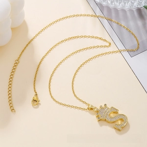 Detailed shot of crown letter S pendant with zircon pavé on gold stainless steel chain