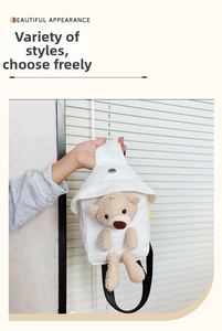 Detail of white canvas kids chest bag featuring a cute 3D plush teddy bear decoration