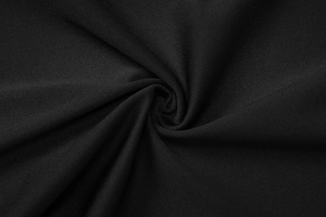 Macro shot of high-quality black textile fabric showing fine knit texture and soft drape