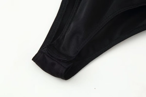 Close-up of snap fastener closure on black sequin long sleeve bodysuit for women