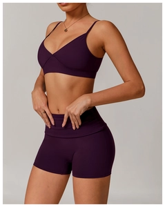Detail of a deep purple seamless high-stretch sports bra and tight yoga shorts set
