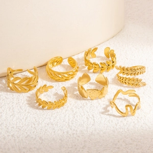 Detailed set of seven golden stainless steel open rings with leaf and geometric patterns
