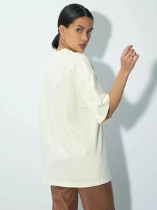 Μινιμαλιστικό κρεμ βαμβακερό oversized t-shirt με στρογγυλή λαιμόκοψη και πεσμένους ώμους