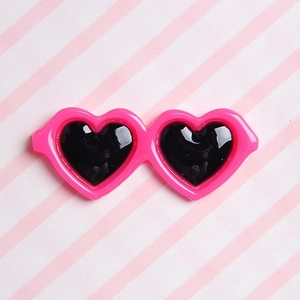 Close-up of pink heart-shaped miniature sunglasses for dolls and DIY crafts