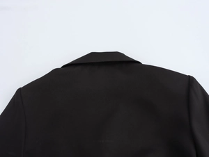 Close-up of the back collar and shoulder tailoring on a black double-breasted long blazer