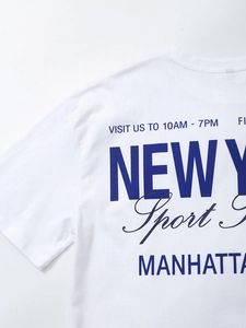 Detail of crewneck collar and navy New York Manhattan print on white cotton T-shirt