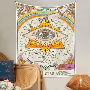 Detail of tarot star tapestry with mystic eye and hands in a cozy boho room setting