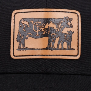 Macro detail of black trucker hat featuring a brown leather cow patch with CF logo