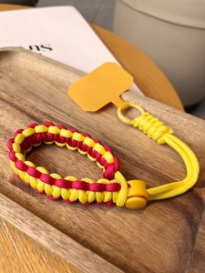 Detail of woven nylon phone wrist strap in red and yellow with adjustable buckle