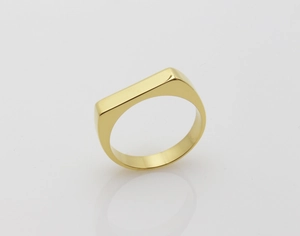 Detailed close-up of a polished gold geometric square signet ring with a mirror reflection
