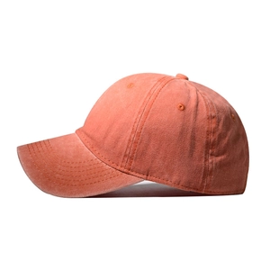 Detail view of coral orange washed baseball cap with six-panel structure and curved brim