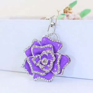 Sparkling purple rose rhinestone keychain with silver metal clip on decorative background