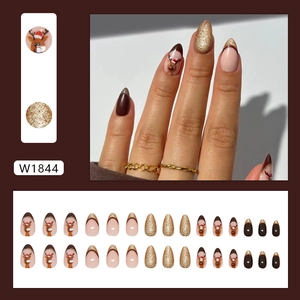 Faux ongles amande marron Noël style French avec motif renne et paillettes dorées