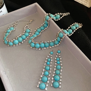 Gros plan d'un ensemble de bijoux bohème avec pierres en résine turquoise sur velours