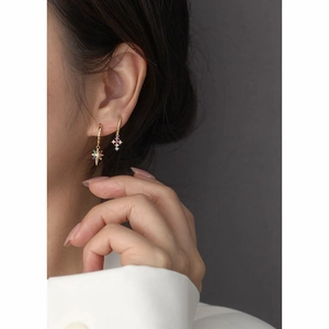 Golden s925 silver star and cross earrings with colorful rhinestones on a model