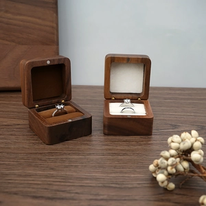 Dual walnut wood ring boxes with velvet lining and flip lids on a rustic table