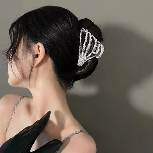 Detail of silver skeleton hand hair claw clip holding hair on a female model