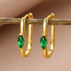 Detail of 18k gold plated hoop earrings with marquise green zircon on a wooden branch