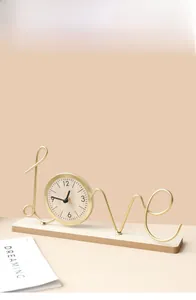 Detail of creative gold metal Love word clock with minimalist wooden base for desk decor