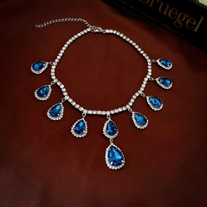 Macro view of luxury teardrop necklace with blue gems and crystal rhinestones