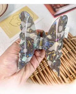 Macro detail of large butterfly hair claw clip with colorful iridescent acetate texture