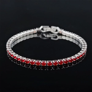 Macro shot of silver hip hop tennis bracelet with red zircon stones and claw setting