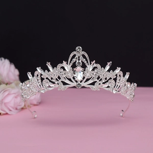Macro shot of silver baroque tiara featuring leaf patterns and pear-shaped crystals