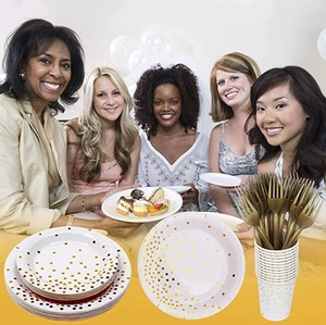 White disposable party tableware set with golden polka dots and matching gold forks