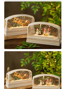 Close-up of a Christmas snow globe music box featuring Santa and snowman scenes with warm LED