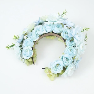 Blue floral headband featuring artificial roses and green leaves on a black base