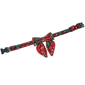 Detail view of red and green plaid Christmas dog collar with snowflake patterns and D-ring