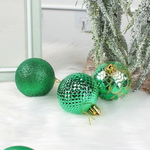 Three green Christmas tree ornaments with glitter, geometric facets, and gold accents
