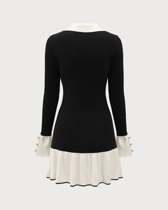 Detail of knitted mini dress back view showing gold buttons on cuffs and ruffle hemline