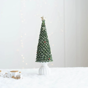 Détail macro d'un sapin de Noël en résine avec étoile dorée et base à relief
